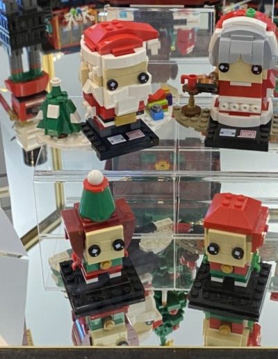 A festive display of Lego Christmas decorations in a glass case.