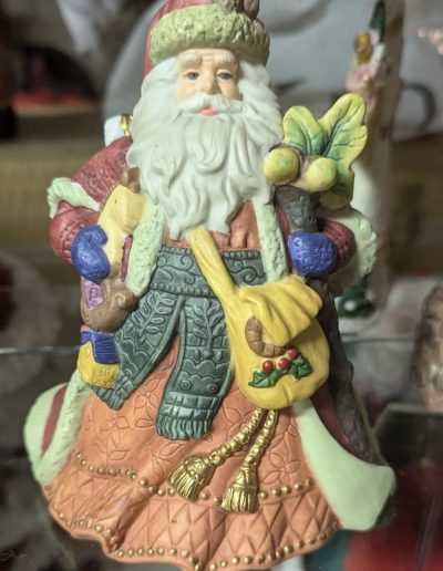 A festive Santa Claus figurine stands proudly, clutching a bag overflowing with presents, symbolizing holiday joy.