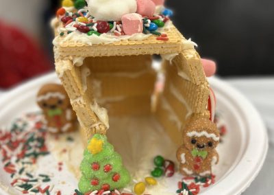 A whimsical gingerbread house designed to resemble Santa's workshop, adorned with colorful icing and candy decorations.